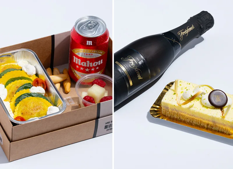 Boxed meal with ravioli, breadsticks, fruit, and a can of Mahou beer on the left; slice of cake and a bottle of Freixenet sparkling wine on the right.