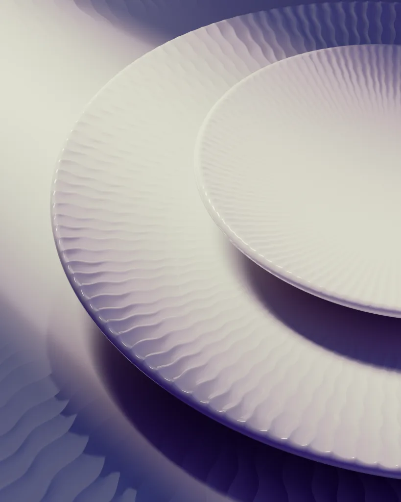 Two white textured ceramic plates, one large and one small, are stacked on a surface with wavy shadows and soft lighting, evoking the refined aesthetic of Anne-Sophie Pic’s Air France tableware.