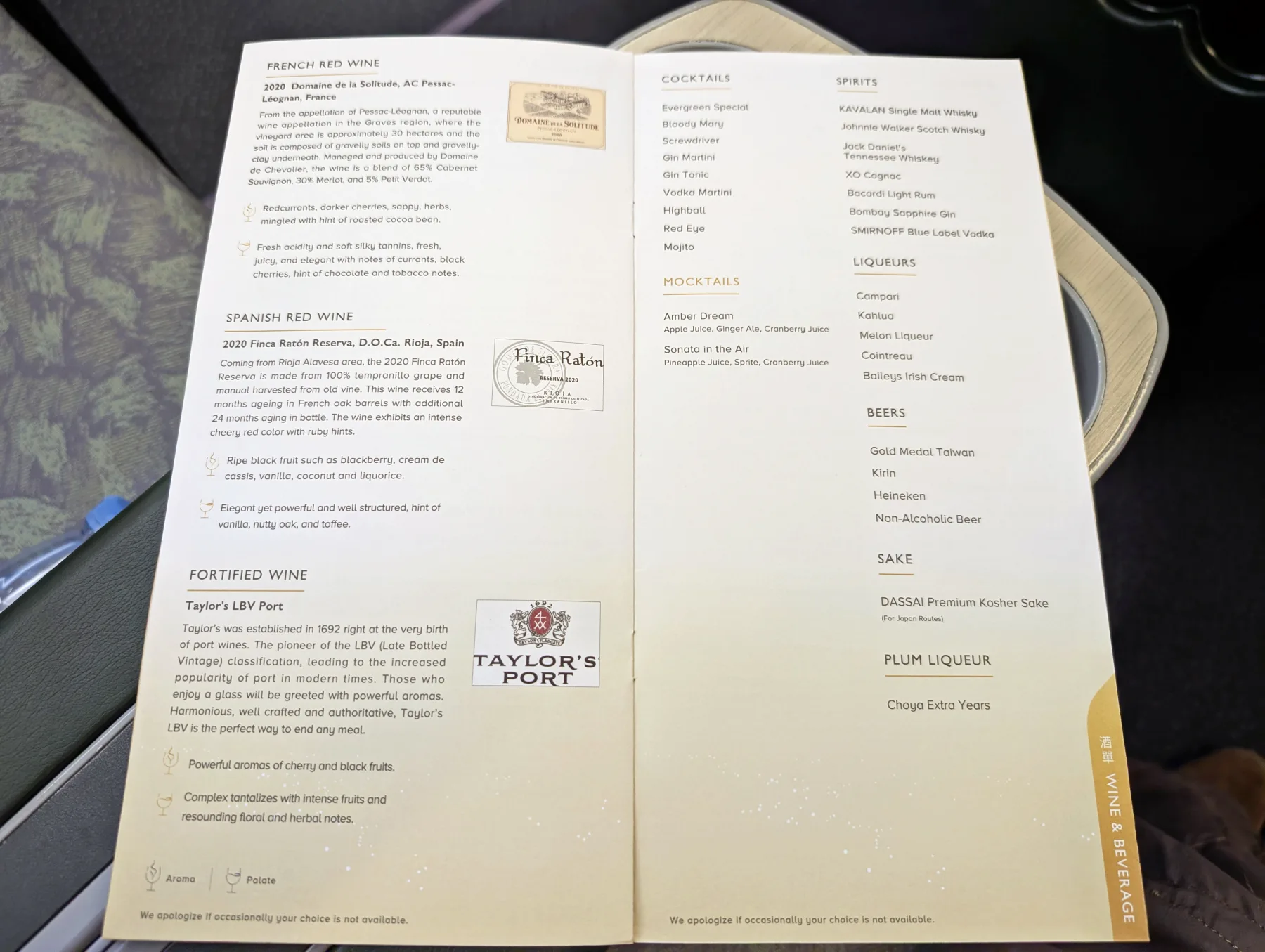 An airline wine and beverage menu listing French and Spanish red wines, fortified wine, cocktails, spirits, liqueurs, beers, sake, and plum liqueur on a cream-coloured background.